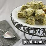 A slice of creamy, cheesy spinach artichoke matzo kugel with a golden-brown top, served on a white plate.