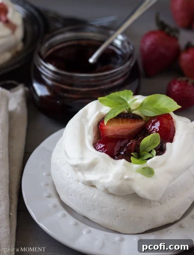 Pavlova topped with cream and strawberries