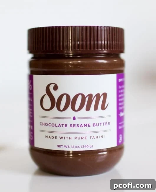 A jar of Soom Chocolate Sesame Butter, the key ingredient for these cookies, sitting on a wooden surface.