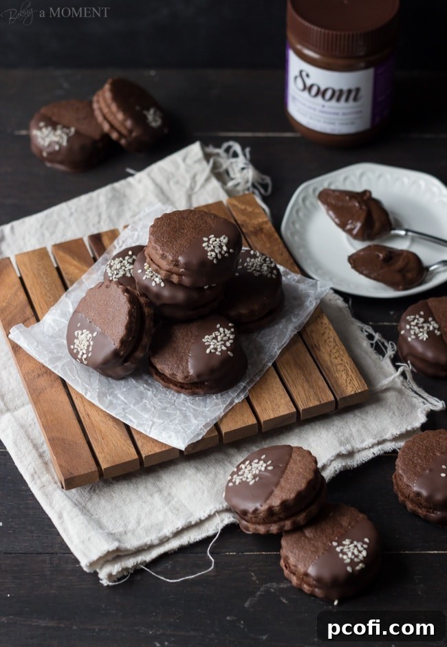 A single Chocolate Sesame Butter Sandwich Cookie, bitten into, revealing the creamy filling.