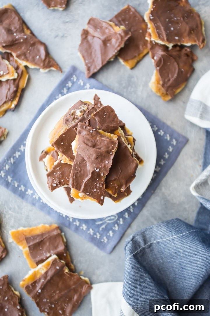 Overhead image of broken pieces of matzo toffee on a gray background, with a blue and white cloth.