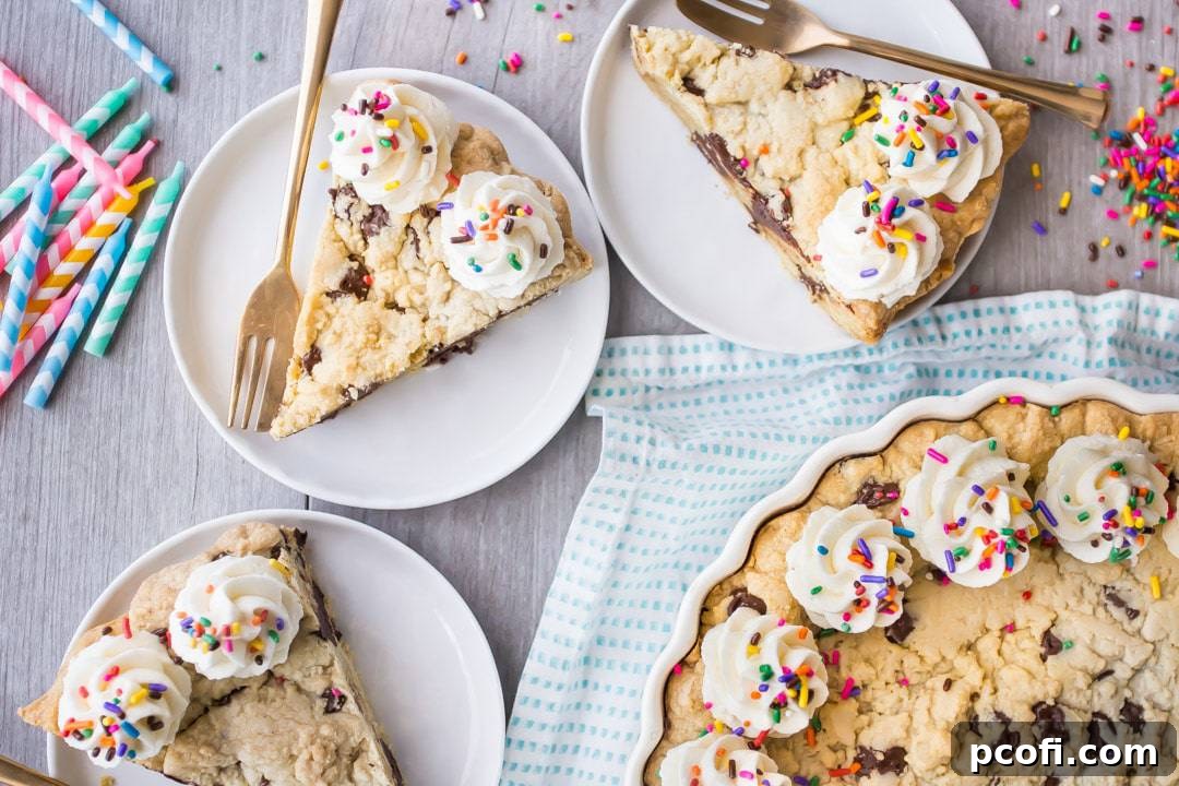 An inviting horizontal overhead image displaying slices of giant chocolate chip cookie cake on plates, accompanied by elegant gold forks and a scatter of rainbow sprinkles, ready to be enjoyed.