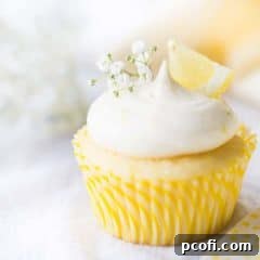 Lemon cupcake with lemon curd filling & lemon cream cheese frosting, garnished with baby's breath and a wedge of fresh lemon.