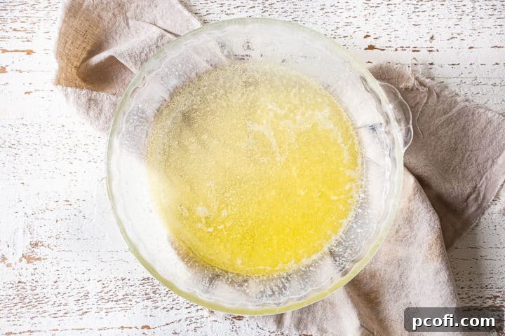 Melted butter pooled in the bottom of a glass pie dish.