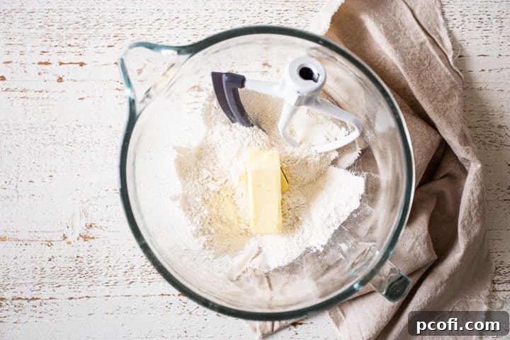 Dry cake ingredients in a large mixing bowl with softened butter ready to be incorporated.