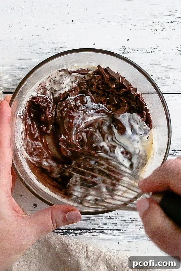 Whisked chocolate, cream, corn syrup, and vanilla creating a rich, shiny glaze ready for drizzling on desserts.
