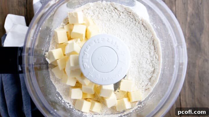 Adding cold, cubed butter to dry ingredients.