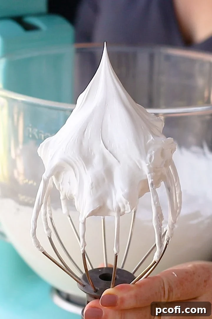 A pristine bowl of stiff, white royal icing, expertly whipped to perfection, suitable for intricate piping of flowers, borders, and sturdy gingerbread house construction.