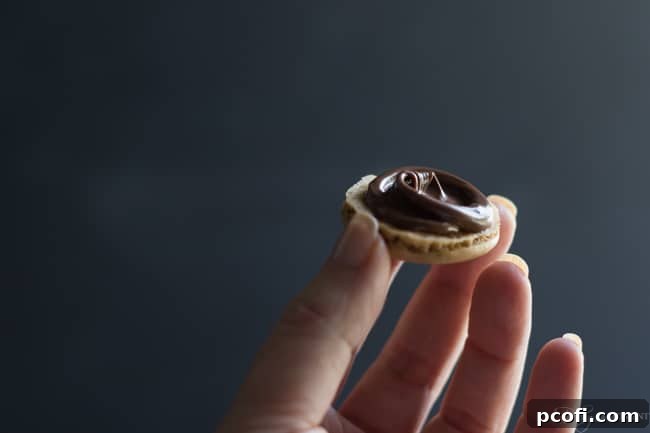 A tray of freshly baked coffee macarons cooling on parchment paper