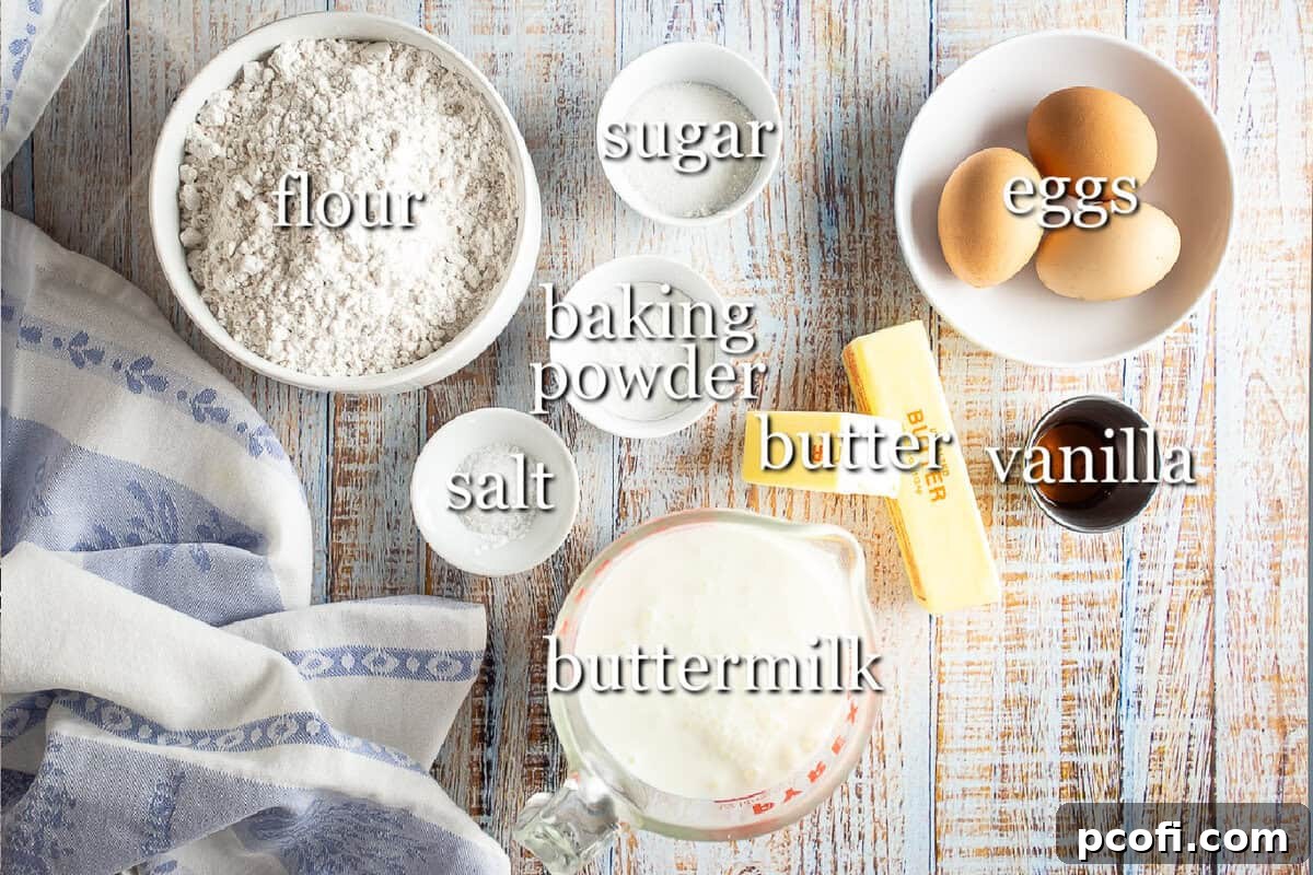 A selection of fresh, high-quality ingredients laid out on a kitchen counter, including flour, sugar, butter, buttermilk, and eggs, essential for making delicious homemade waffles.