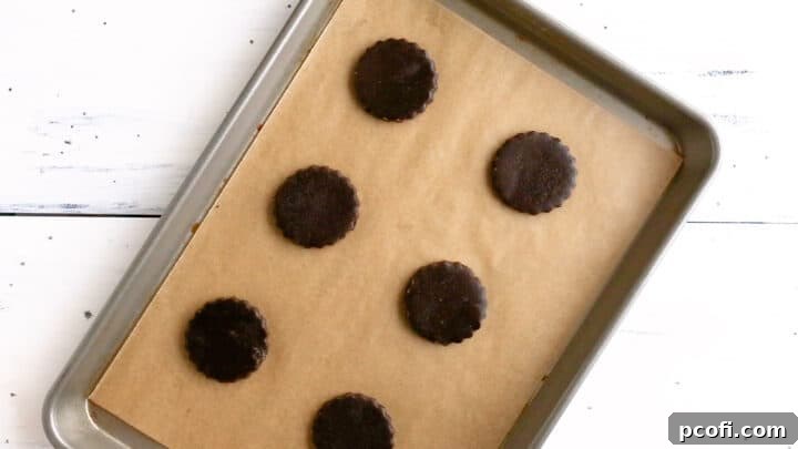 Unbaked homemade Oreos neatly arranged on a parchment-lined baking sheet, ready for the oven.