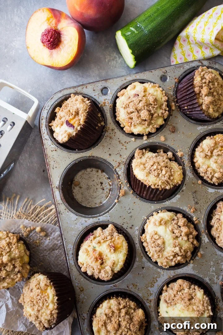 Delicious Peach Zucchini Coffee Cake Muffins with a crumb topping, garnished for serving.