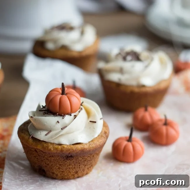 Delicious Pumpkin Chai Cupcakes topped with creamy buttercream frosting and festive fondant pumpkins, ready for a holiday celebration.