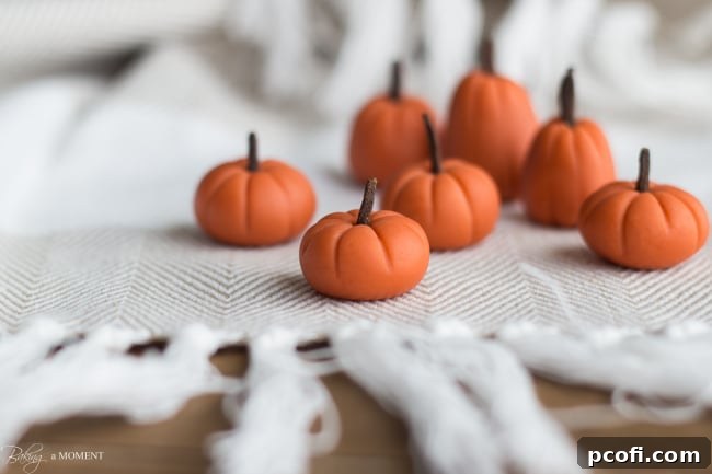 Cute handmade fondant pumpkins with clove stems, perfectly crafted for cupcake garnishes.