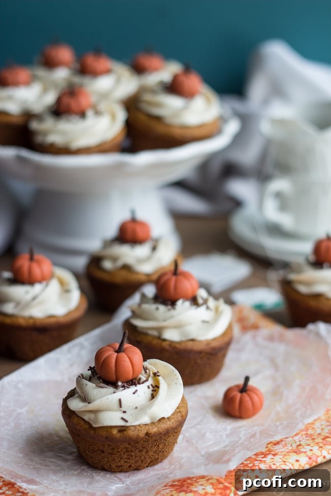 Beautifully decorated Pumpkin Chai Cupcakes, topped with rosette-piped chai buttercream and miniature fondant pumpkins.
