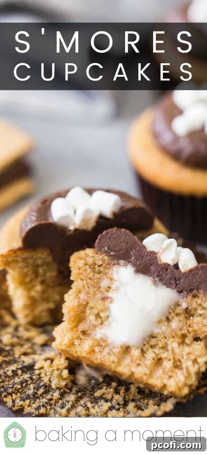 Close-up image of a s'mores cupcake, cut in half to show the marshmallow filling, with a text overlay above that reads 