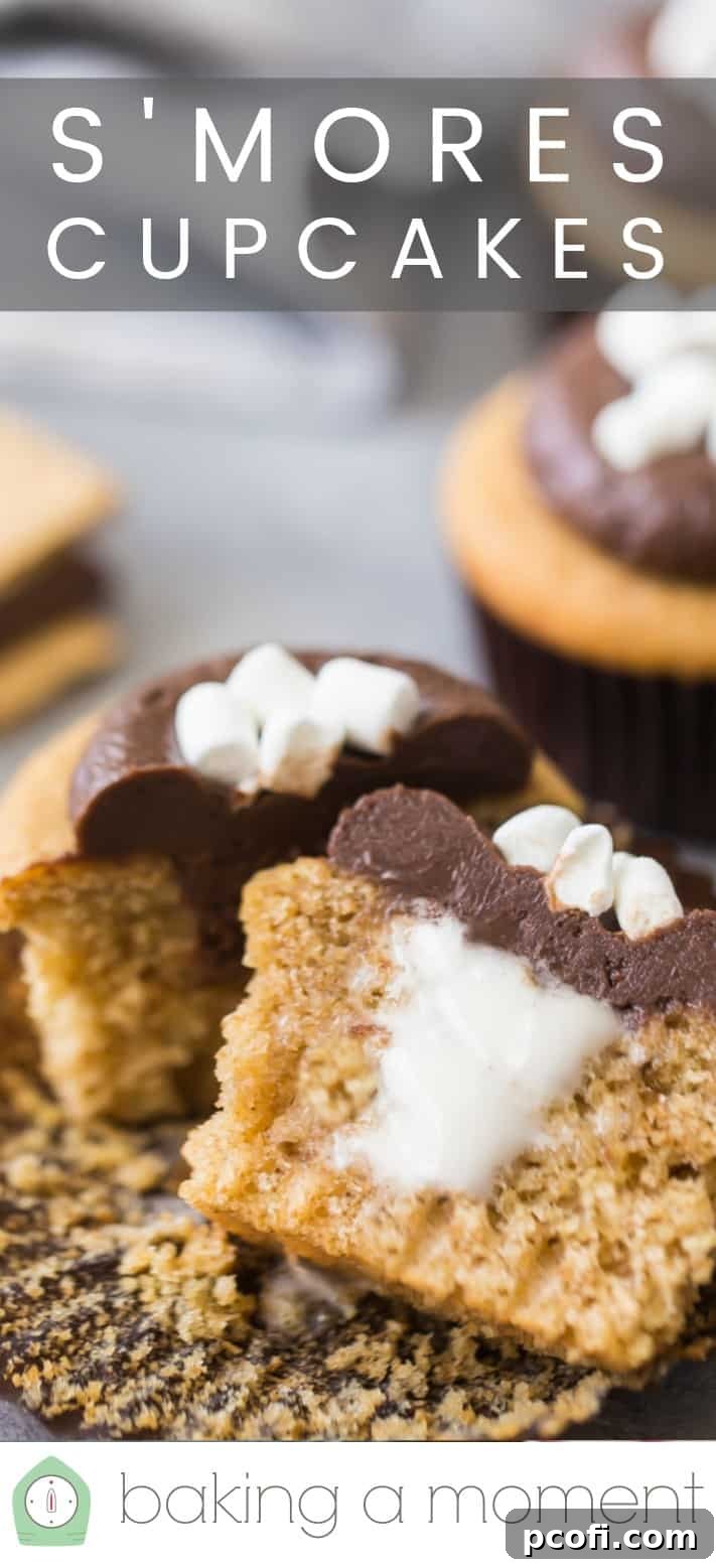 Close-up image of a s'mores cupcake, cut in half to show the marshmallow filling, with a text overlay above that reads 