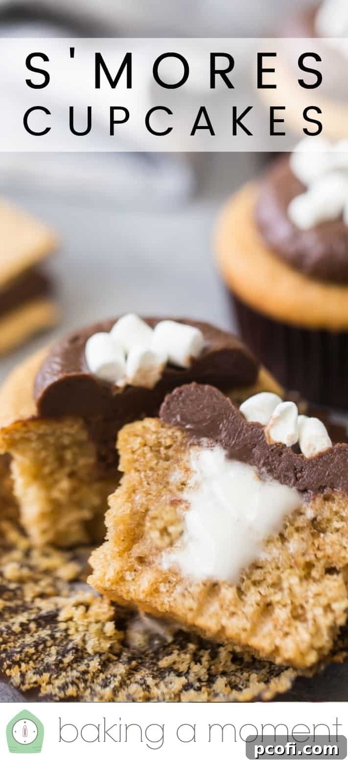 Close-up image of a s'mores cupcake, cut in half to show the marshmallow filling, with a text overlay above that reads 