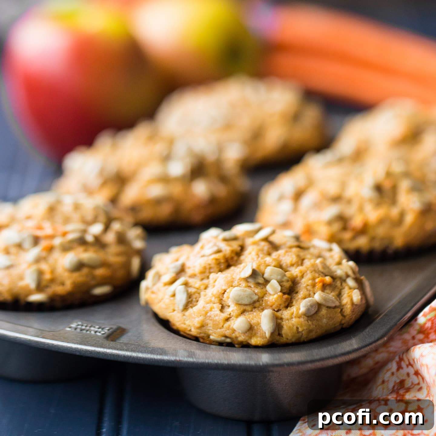 Close-up of perfectly baked Best Morning Glory Muffins Recipe with sunflower seeds on top and a tender crumb visible