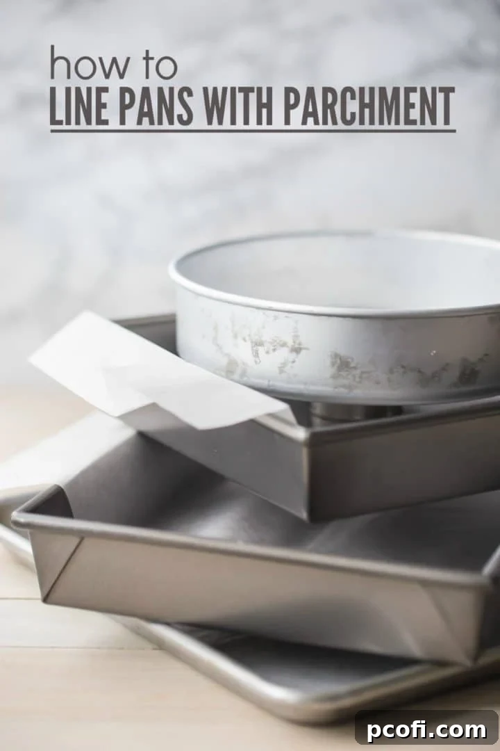 Hands lining a baking pan with parchment paper