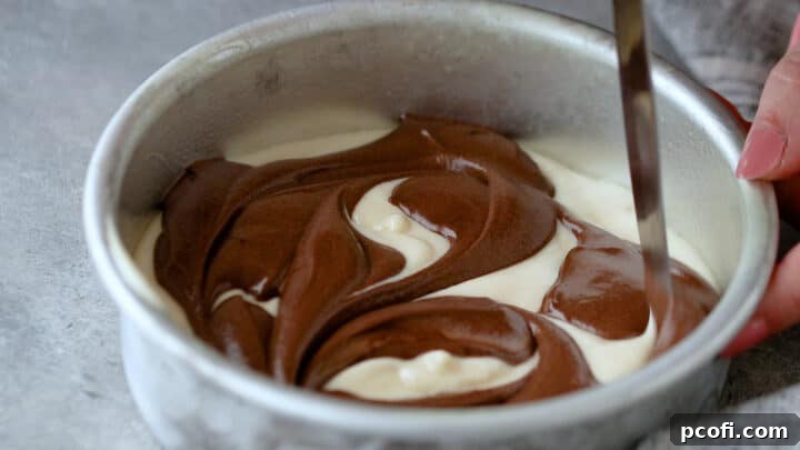 Swirling chocolate and vanilla cake batters together in a cake pan with the tip of a sharp knife to create the marble effect.