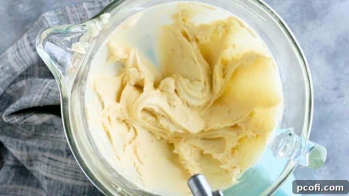 Smooth cake batter after eggs have been fully incorporated, ready for the next liquid additions.