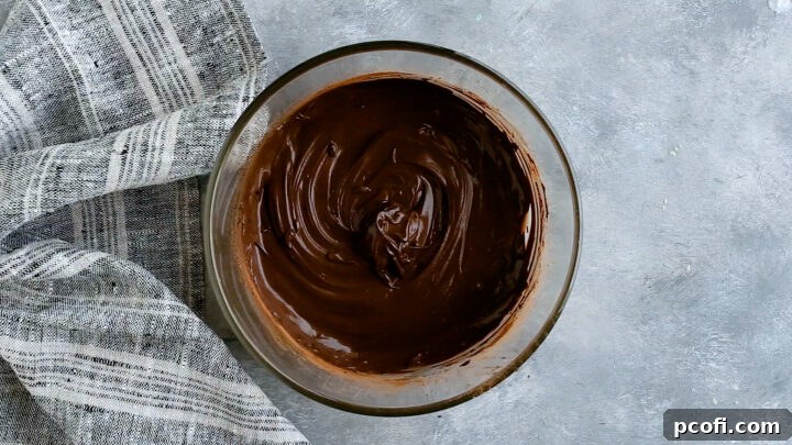 Unsweetened cocoa powder and hot water stirred together until a smooth chocolate paste forms, ready for batter.