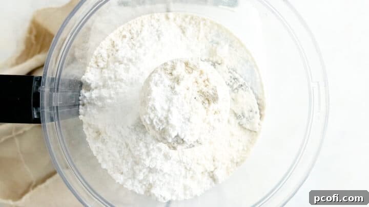 Dry ingredients for making tart crust in the bowl of a food processor.