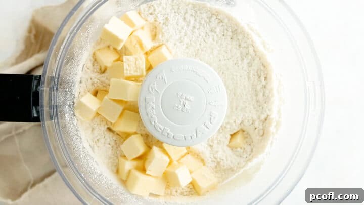 Adding cold butter to dry ingredients in a food processor for tart dough.