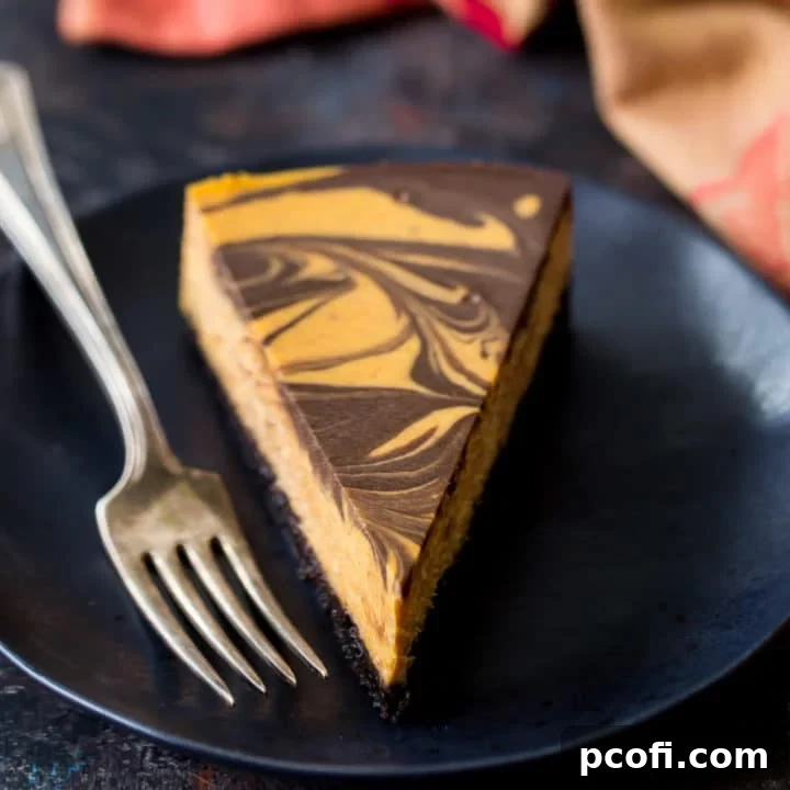 Rich Pumpkin Chocolate Swirl Cheesecake with a dark chocolate cookie crust, topped with an elegant marble pattern. A perfect dessert for fall, Halloween, or Thanksgiving celebrations.