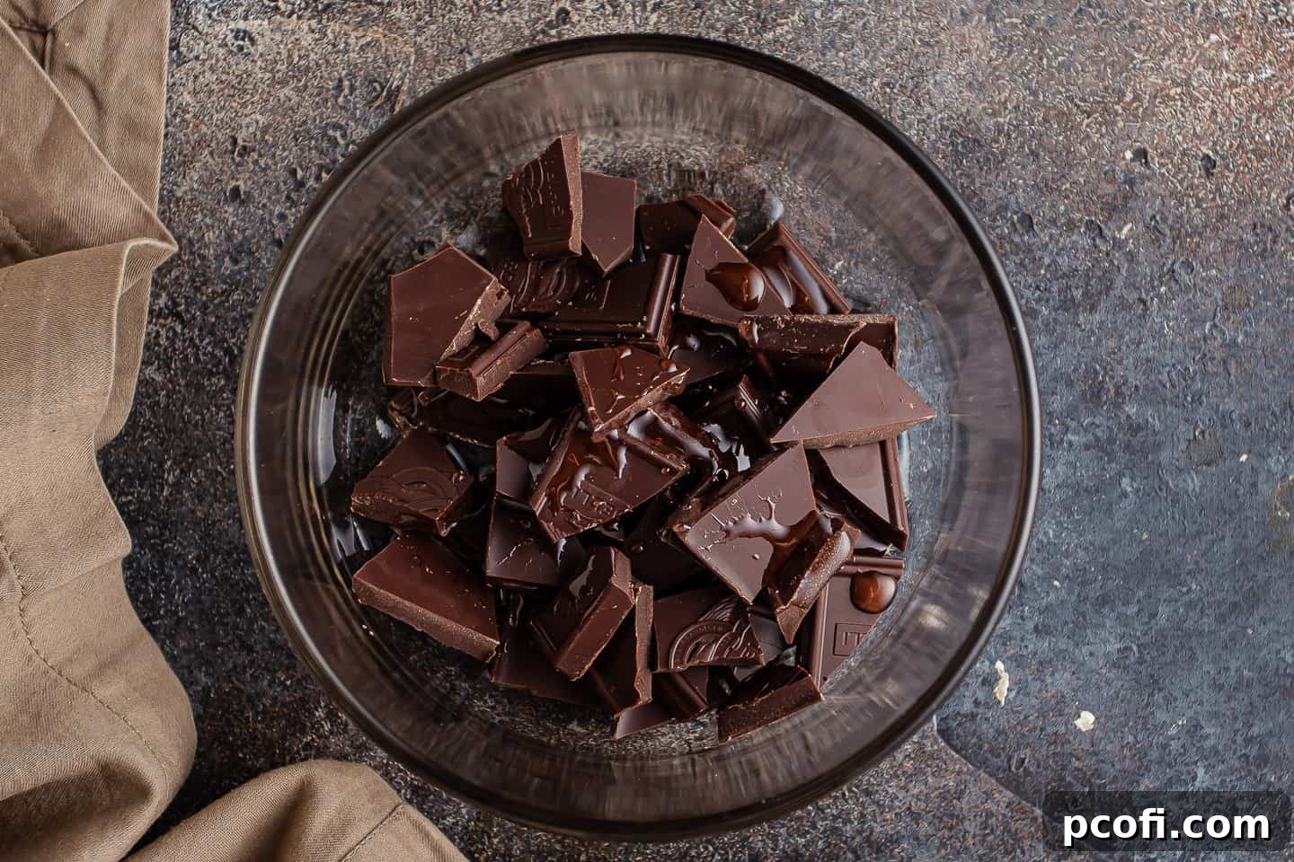 Finely chopped chocolate and a spoonful of corn syrup ready in a small bowl, the base for the silky chocolate glaze.