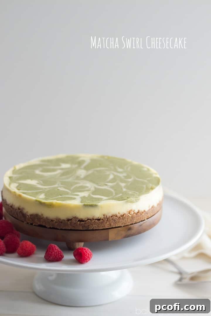 Close-up shot of a perfectly sliced matcha cheesecake, revealing the delicate green swirl within the creamy white filling and the golden-brown spiced crust.