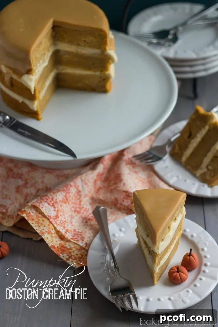 Close-up slice of Pumpkin Boston Cream Pie, revealing the moist spiced pumpkin cake layers, the creamy maple custard filling, and the glistening caramelized white chocolate ganache.