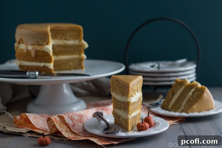 An overhead shot of the complete Pumpkin Boston Cream Pie, meticulously layered and topped with a perfectly smooth and shiny caramelized white chocolate ganache, ready for slicing.