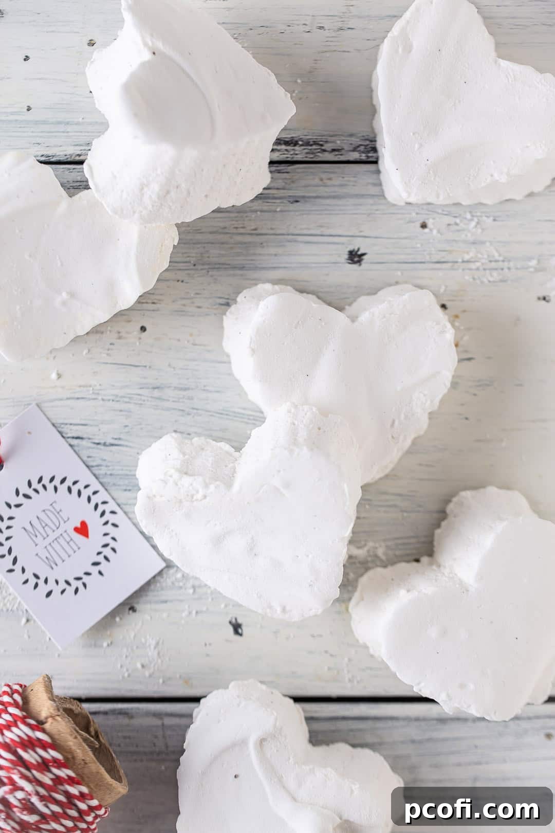Heart-shaped homemade marshmallows arranged beautifully on a rustic wooden table.