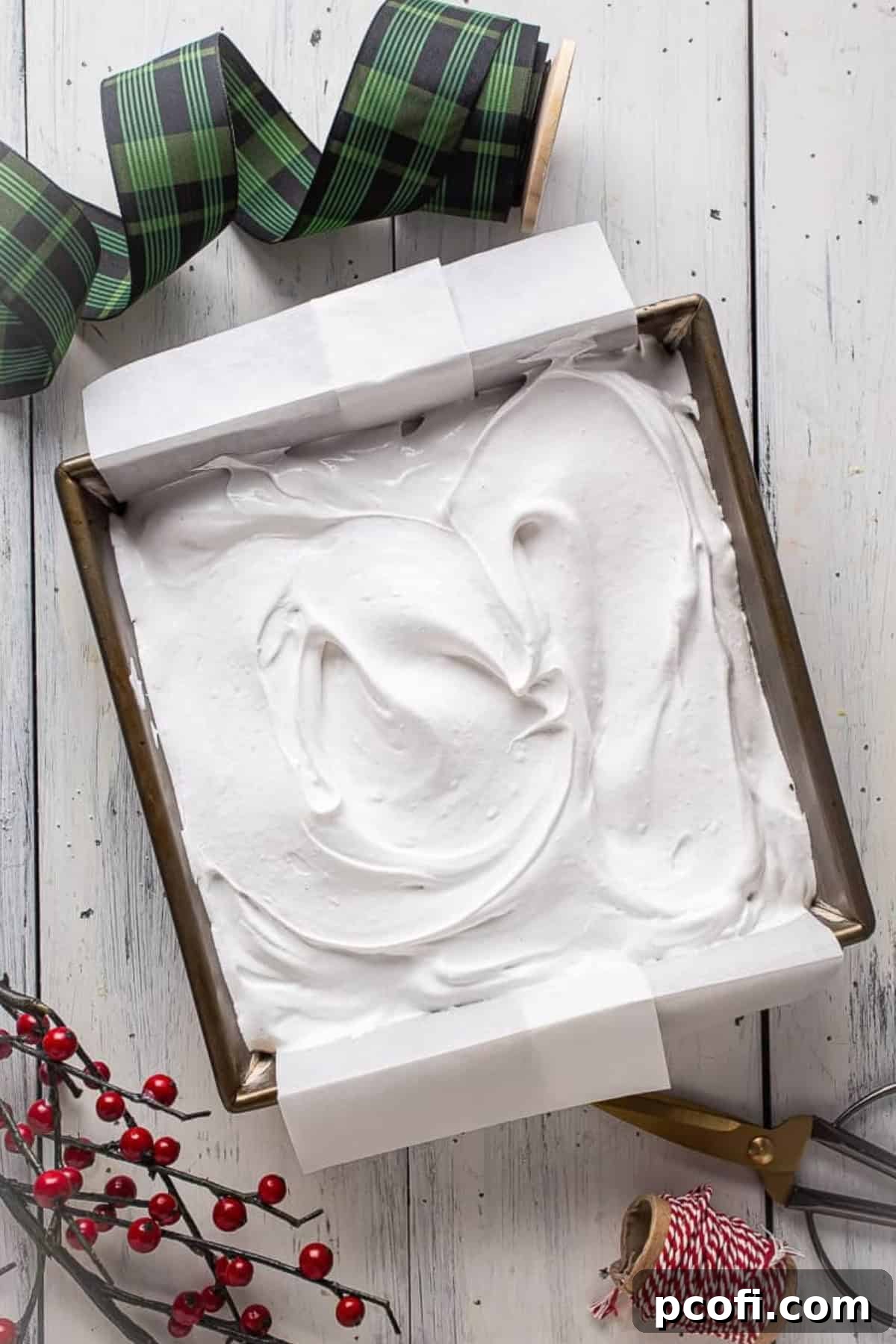 Marshmallow cream spread evenly into a square baking pan, ready to set.