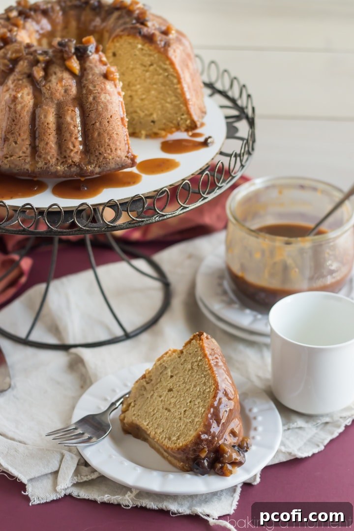 A generous slice of Chestnut Praline Coffee Bundt Cake, showcasing the light, airy texture and rich topping, served on a plate.
