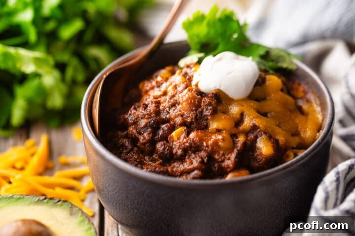 Vegetable chili recipe, cooked and served with fresh avocado slices and cilantro.