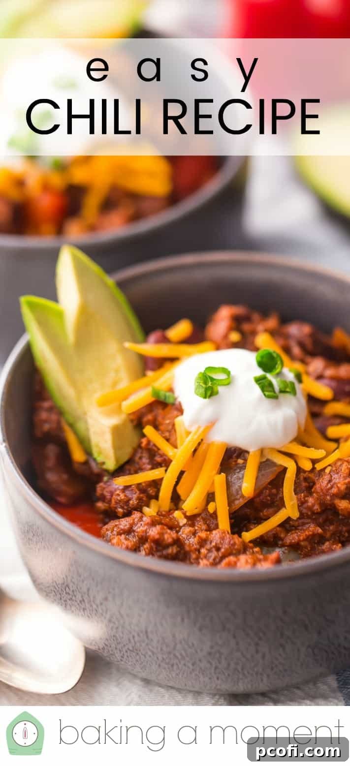 Close-up image of a bowl of chili, topped with cheese, sour cream, and avocado, with a text overlay reading "Easy Chili Recipe."