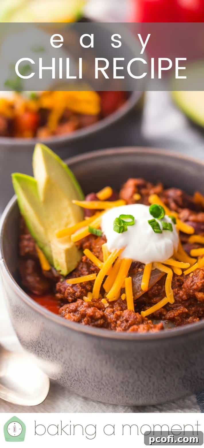 Close-up image of a bowl of chili, topped with cheese, sour cream, and avocado, with a text overlay reading "Easy Chili Recipe."