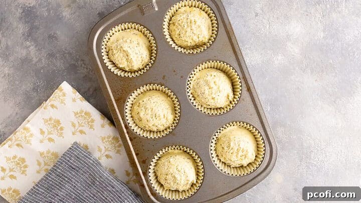 Unbaked lemon poppy seed muffins ready in a standard-sized muffin tin.
