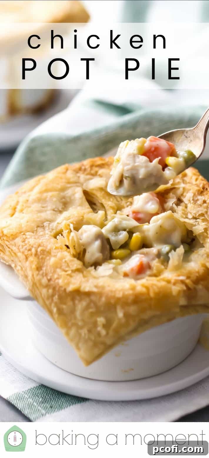 Close-up image of a spoon digging into a pastry-topped chicken pot pie, revealing the creamy filling.