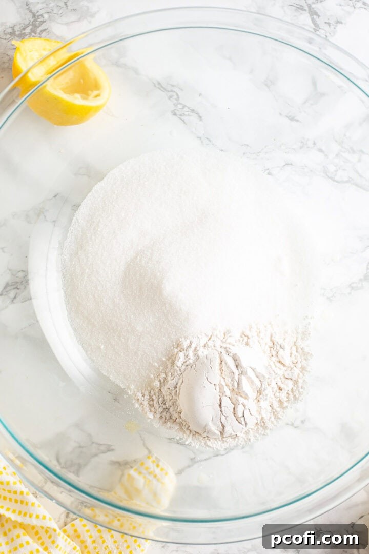 Sugar and flour in a large glass mixing bowl.