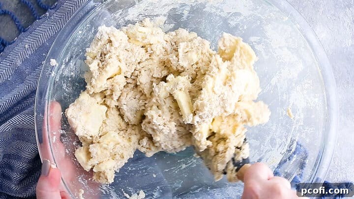 Making homemade croissant dough in a large glass bowl.