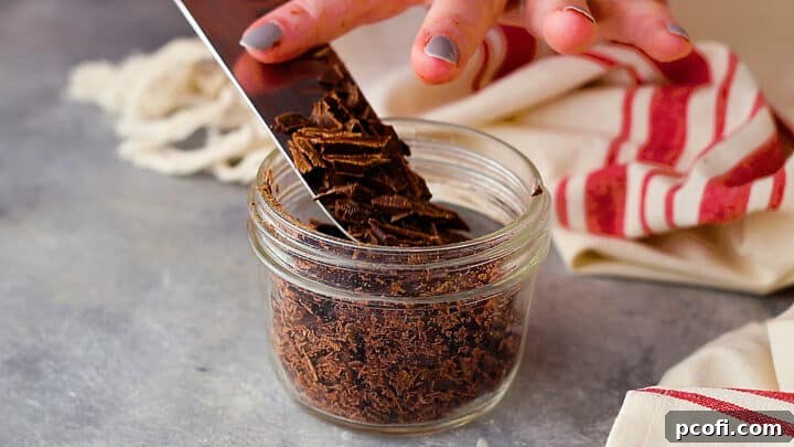 Placing chopped bittersweet chocolate in a small, tall bowl for melting.
