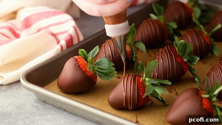 Drizzling milk chocolate over chocolate-covered strawberries for an elegant garnish.