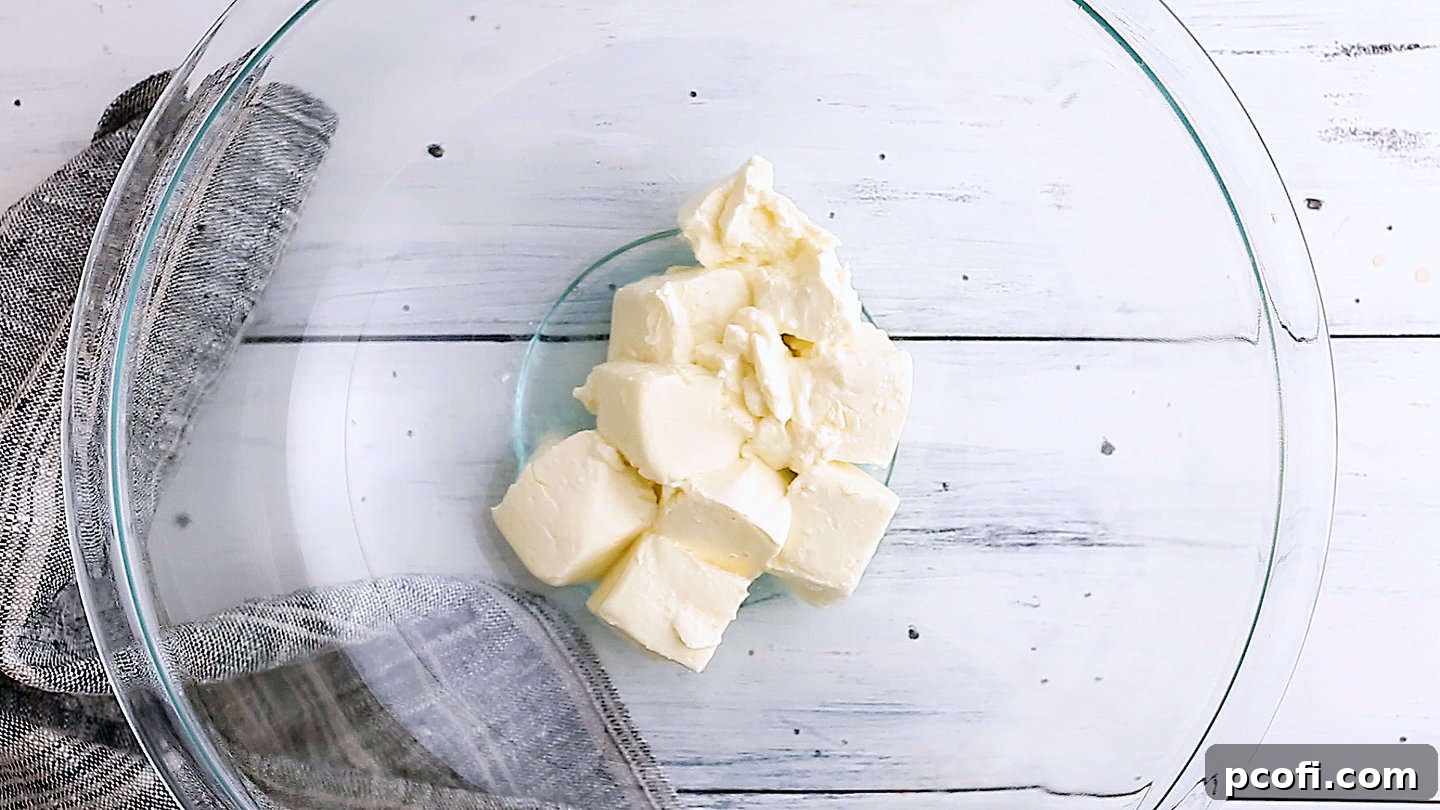 Softened cream cheese in a large glass bowl, ready for the next ingredients.