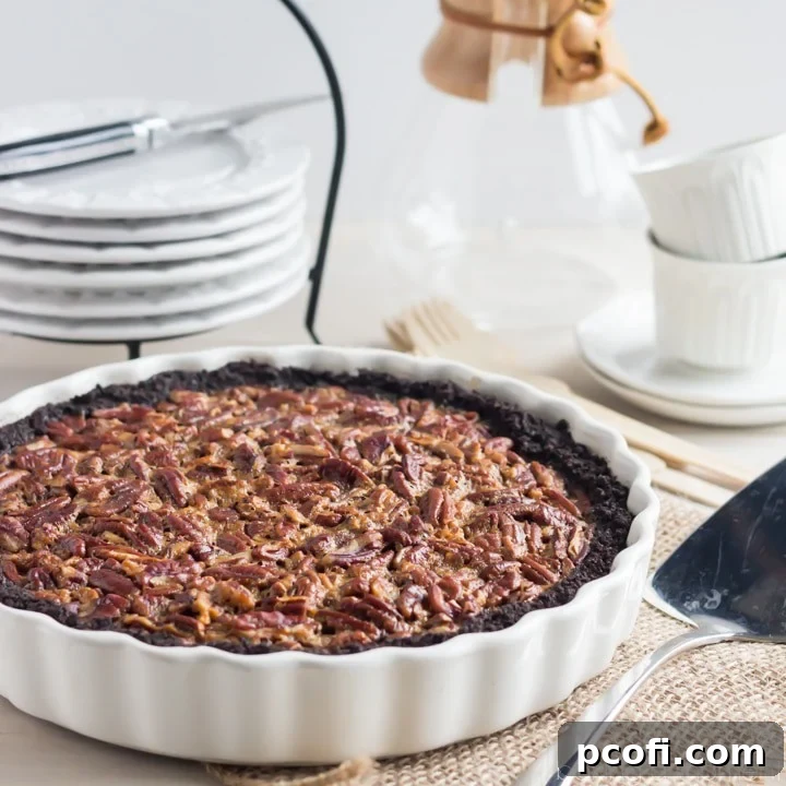 Decadent Chocolate Pecan Tart with a rich Chocolate Cookie Crust, made without corn syrup, featuring brown sugar, honey, maple, and a hint of bourbon. Perfect for dessert!