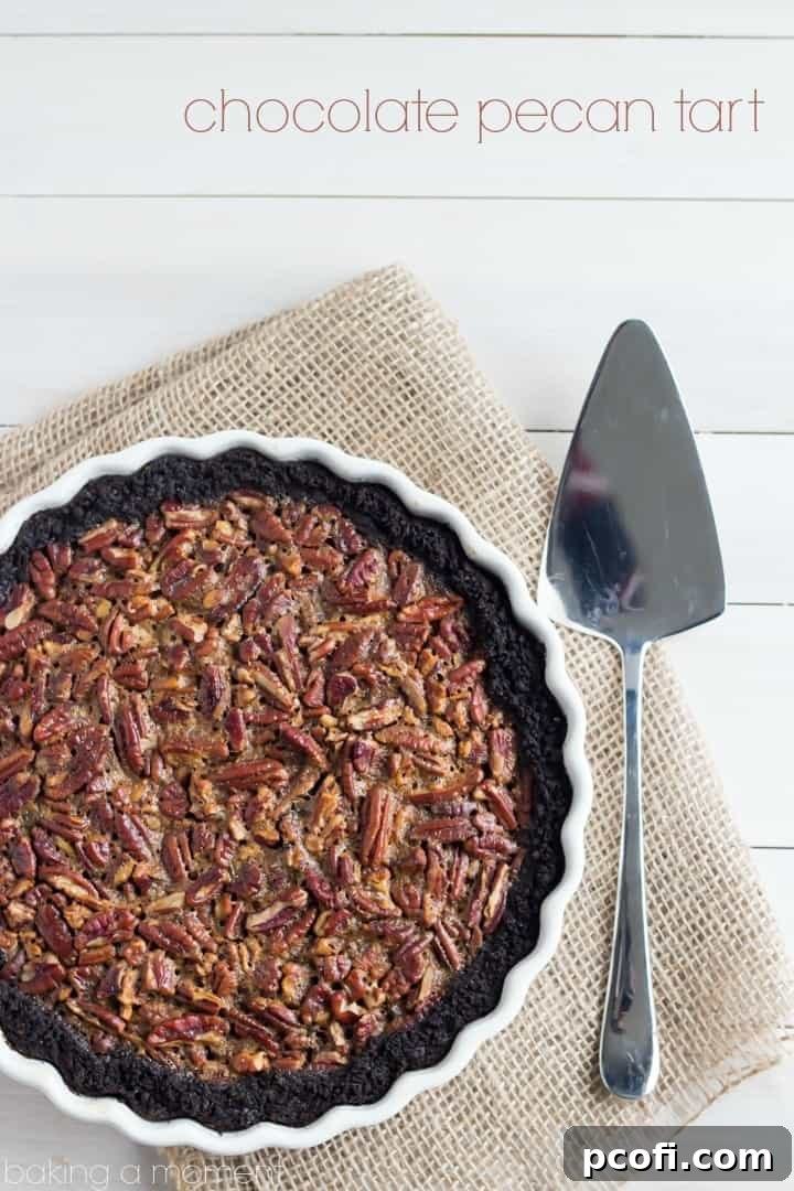Close-up of a slice of Chocolate Pecan Tart, showcasing the crunchy chocolate cookie crust and the glistening, gooey pecan filling. Made with brown sugar, honey, and maple, and a touch of bourbon.