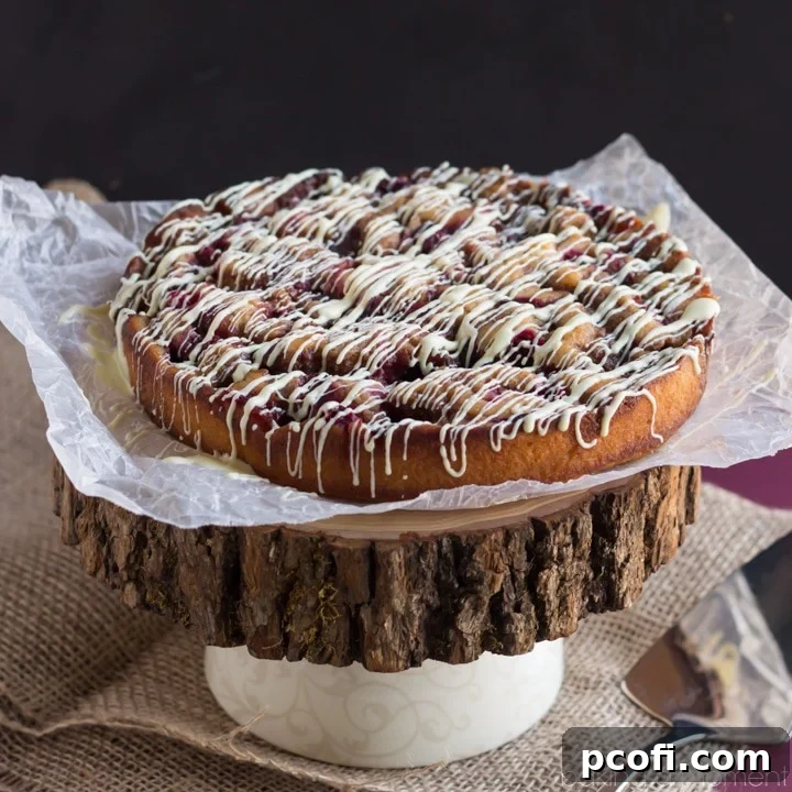 Fluffy Cranberry Cinnamon Coffee Cake with sweet white chocolate glaze, perfect for a no-fuss holiday breakfast or brunch. Tastes like a gourmet cinnamon roll but requires no kneading or rising time. An easy recipe for festive mornings.